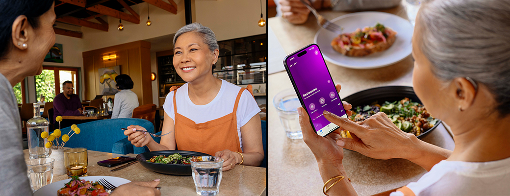 Image of female hearing aid wearer eating at a restaurant and using the My Starkey hearing aid app